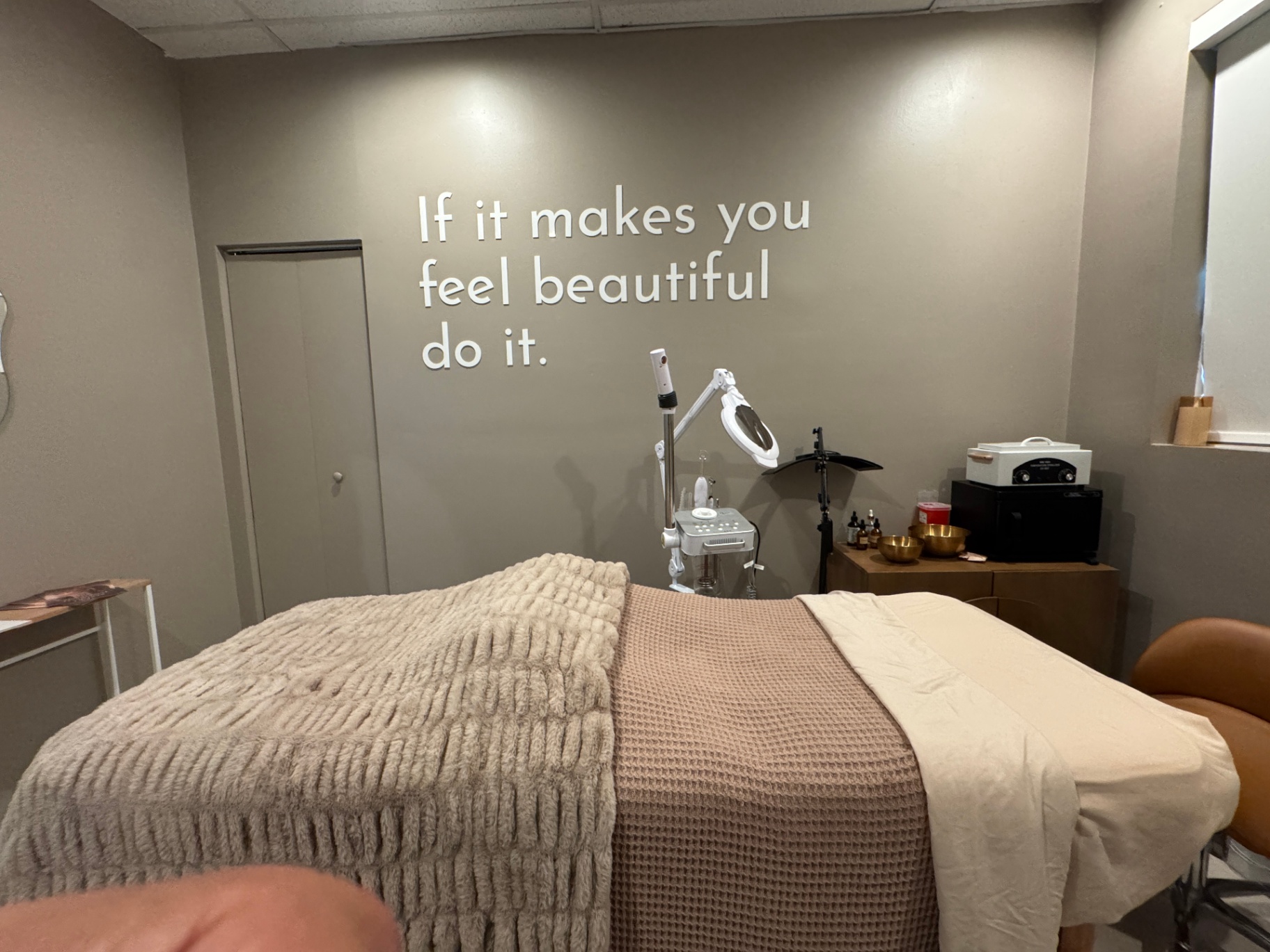 Treatment room at Hydra Prime with wall text 'If it makes you feel beautiful do it'